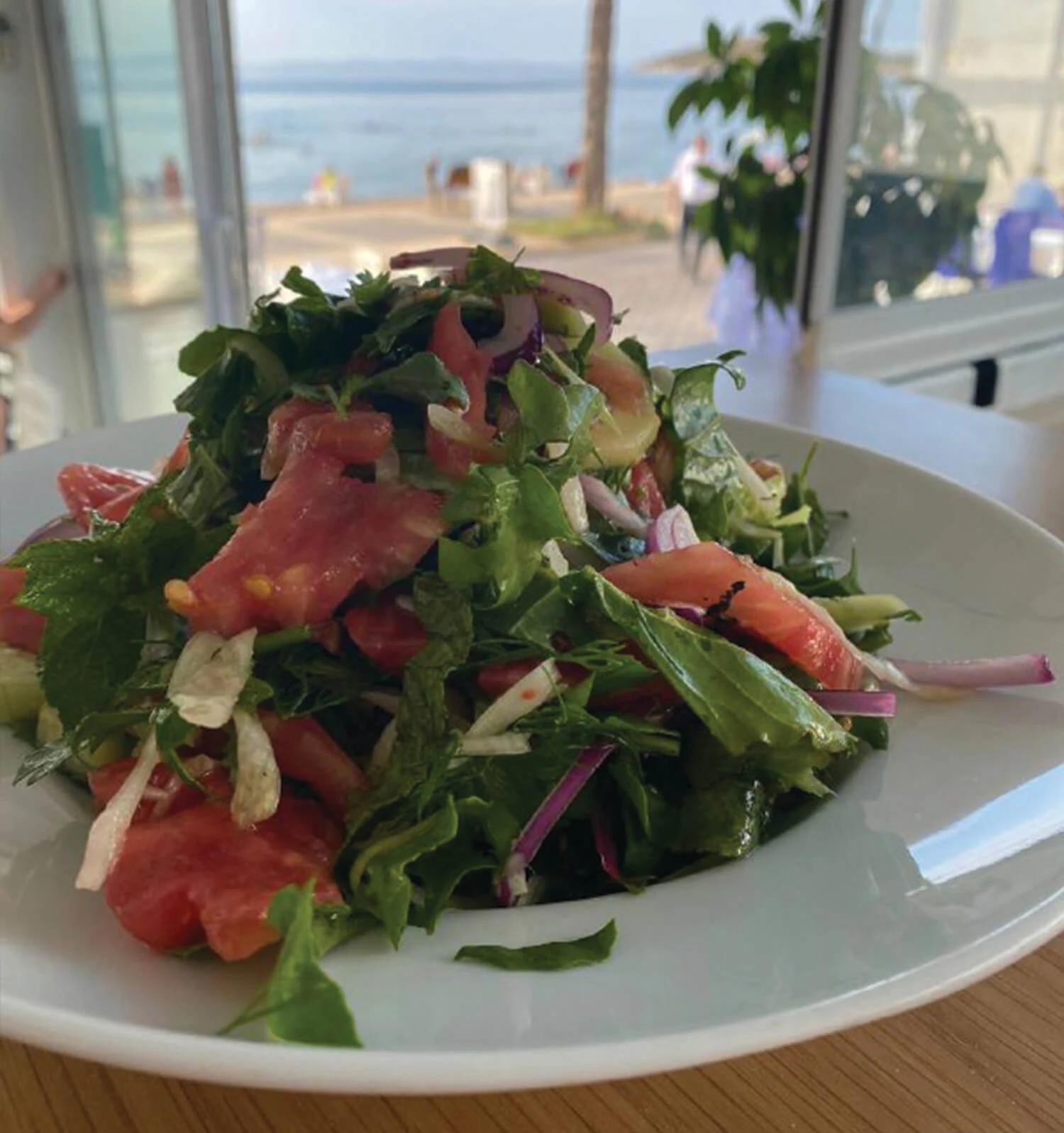 Salonis Restoran — Salad by a window overlooking the sea