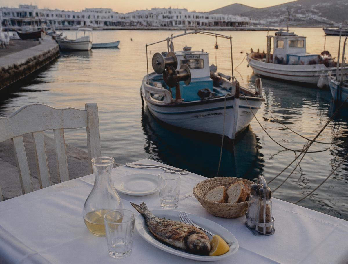 Seafood mezze table set beside the water at golden hour